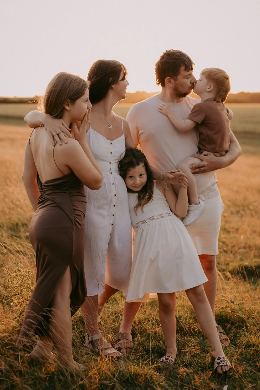 Family of 5 during a sunset walk, little boy giving his dad a kiss. Leeds candid family photography