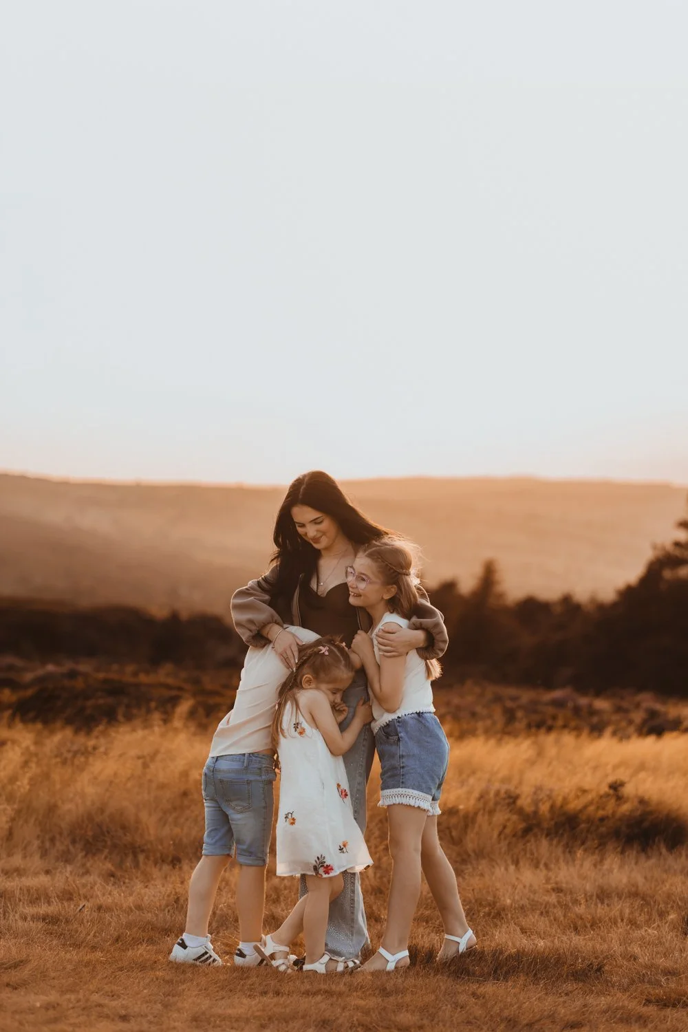 3 young siblings hugging their big sister during their family shoot in Ilkley Moor, Yorkshire