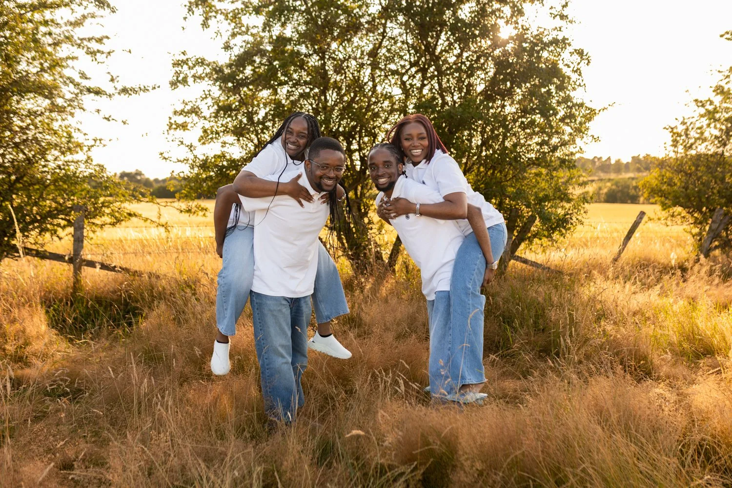 2 brothers giving their 2 sisters piggy back rides during their family shoot in Leeds