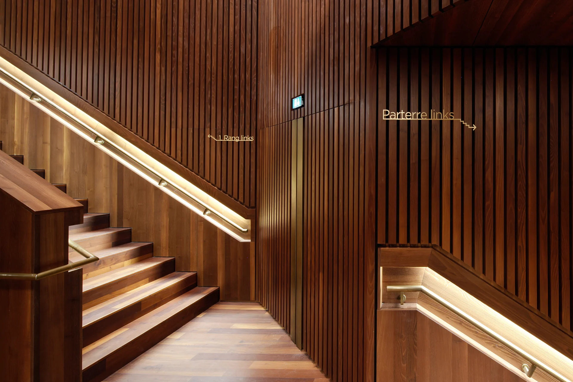 Wegweiser im Großen Saal. Materialität und Farbigkeit der Beschriftung sind von der Innenarchitektur abgeleitet.