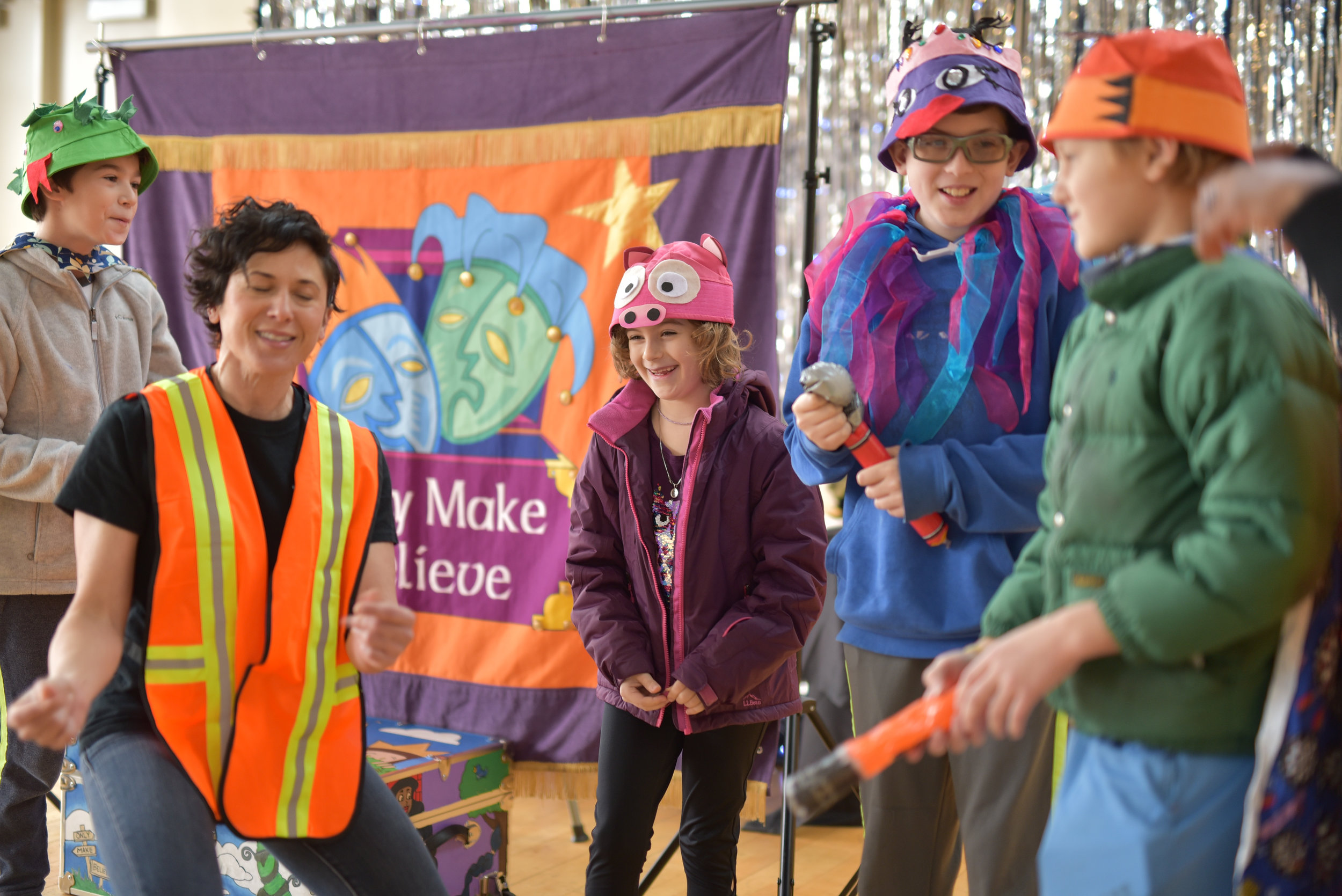 Children and actor playing during children's theatre performance