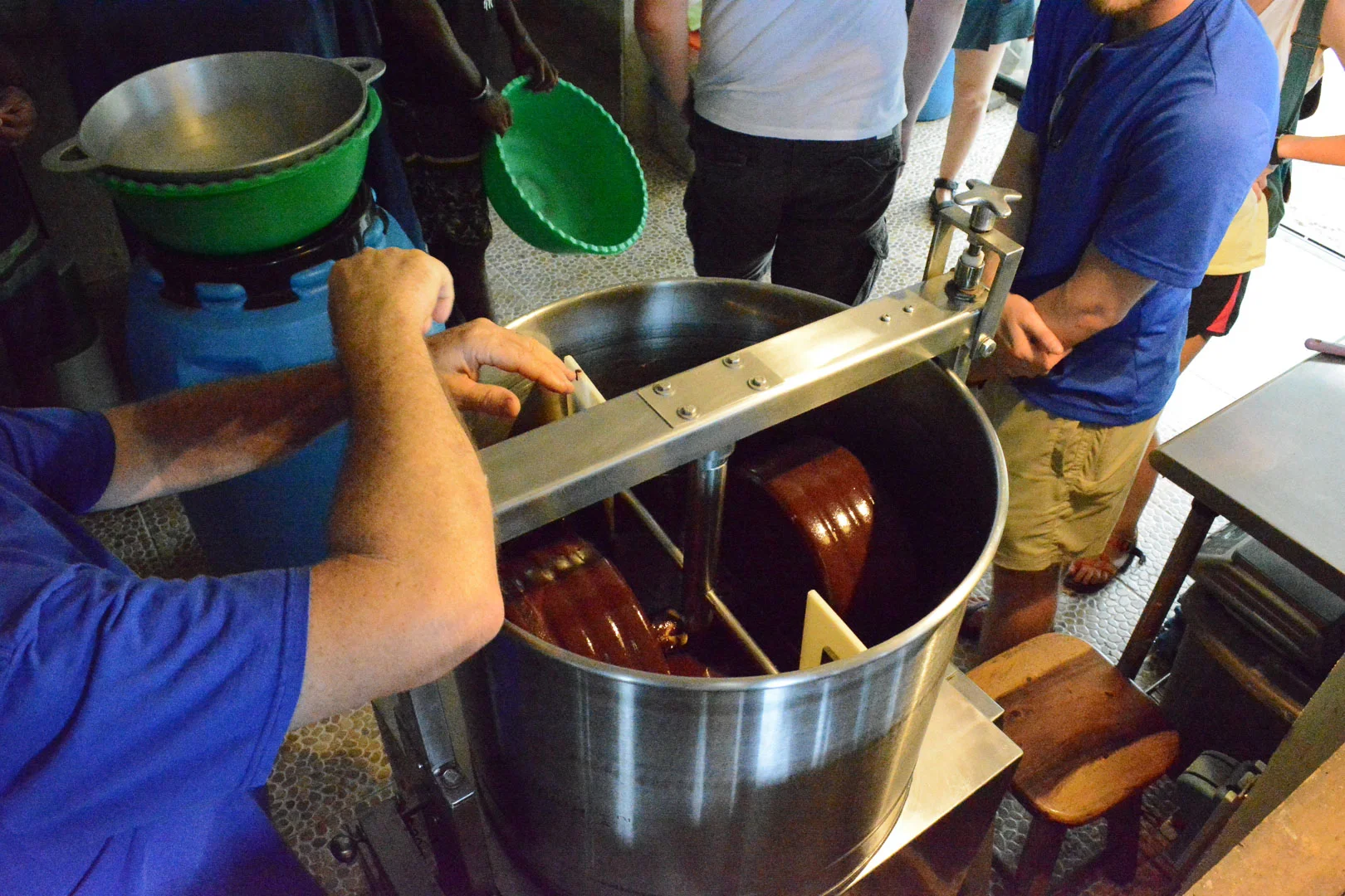 Explaining the process of tempering. They use a bowl over another bowl of ice to cool down the chocolate liquid