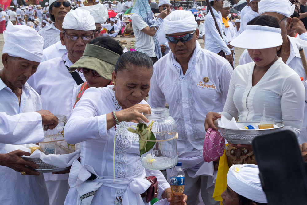 A woman with ocean water splashes everybody and shrine objects for purification