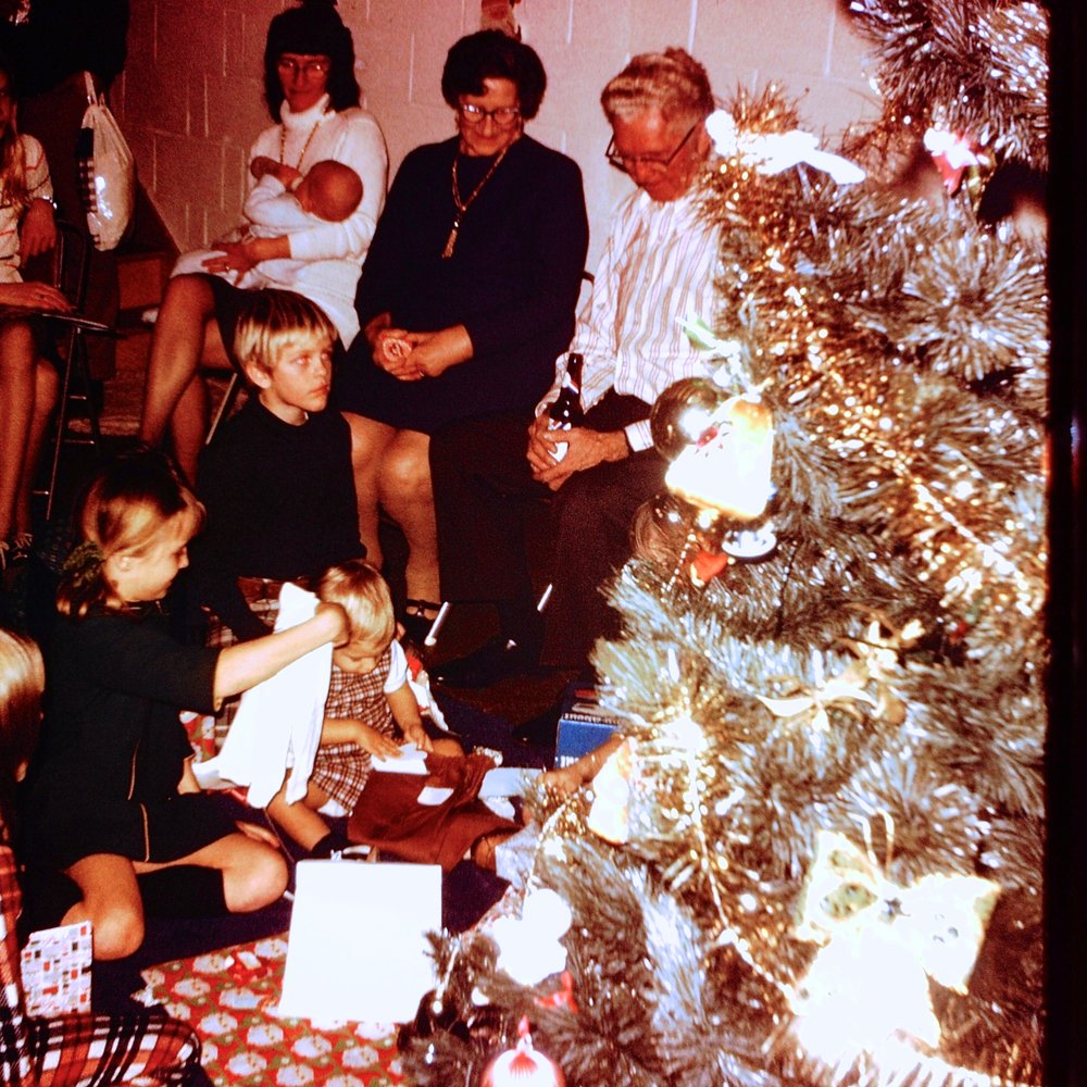 Another from 1973: I see Grandma and Grandpa, Auntie MaryAnne holding Tony, cousins Jim and Steve and my sister Lori all digging that aluminum Christmas tree!