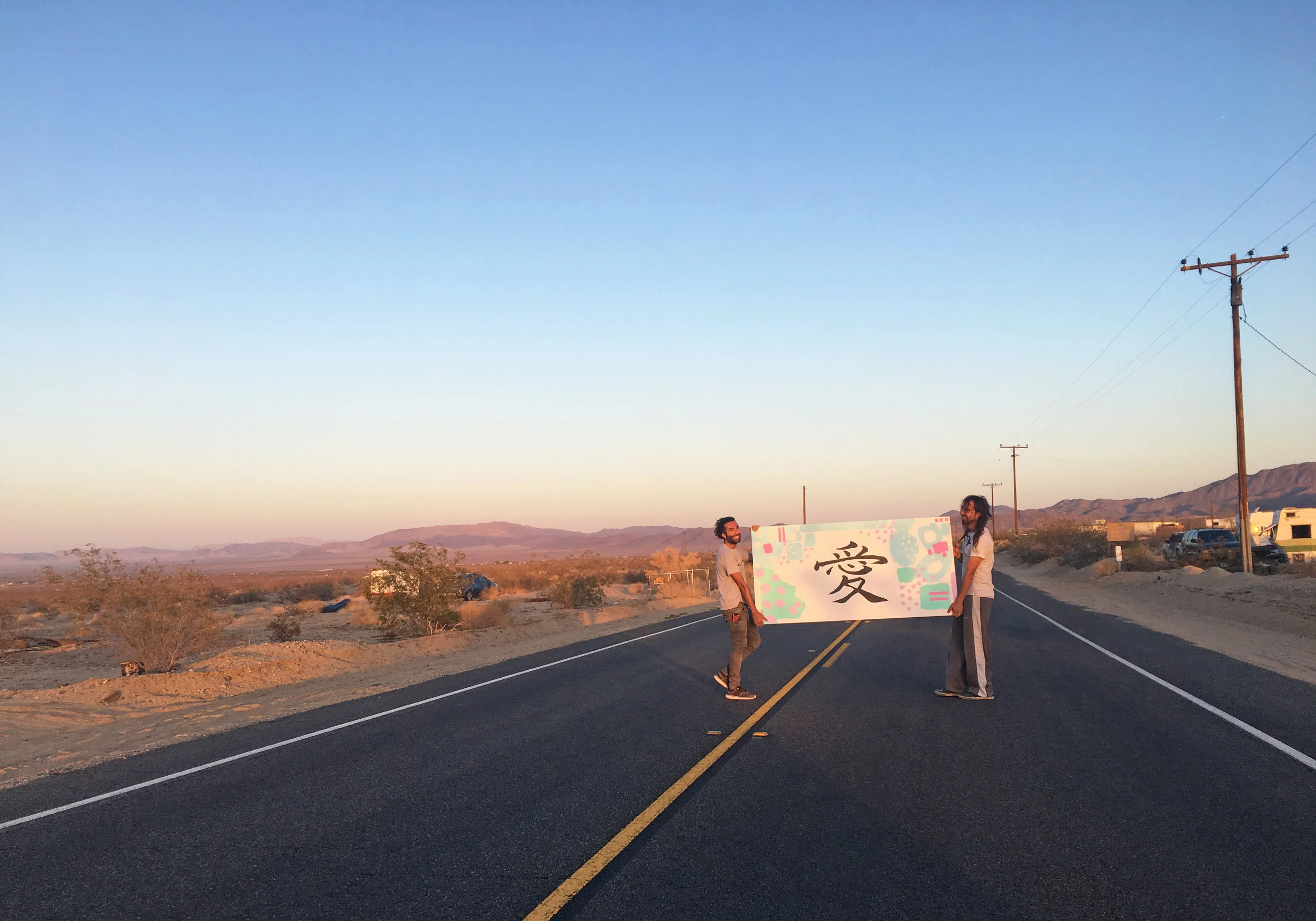 Jacob Rafati and Jose Deangulo transporting a sign to the installation site.