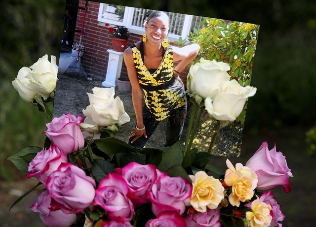 来自《西雅图时报》。在她去世后，在她曾住过的马格努森公园的公寓楼外，摆放了一张查莉娜-莱尔斯的照片和鲜花。(Ken Lambert/The Seattle Times)