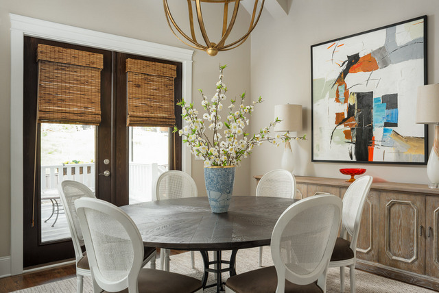 In this Chattanooga dining room, we combined traditional French Louis chairs with modern art and a contemporary light fixture. More contrast is provided between the rough texture of the bamboo shades and metallic accents on the slick white and gold lamps. OH, and that’s a vintage carnival glass compote on the contemporary buffet!