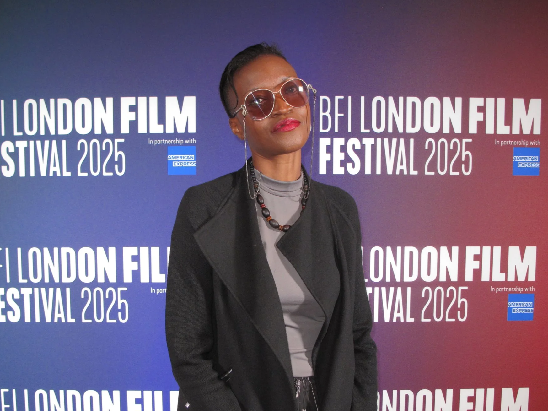 Eno Enefiok posing in front of a backdrop at the BFI London Film Festival 2025 at the world premiere of her award nominated stop-motion short Hope is Lost