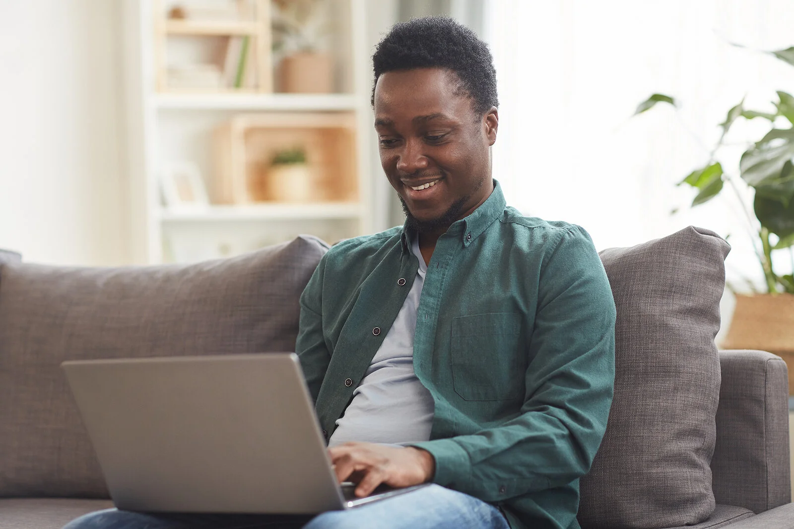 Happy African American man logs into his computer. Healing from trauma doesn't have to mean driving across town because online trauma therapy in North Carolina brings expert care straight to you.