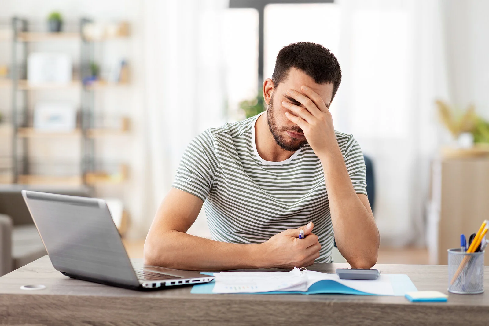 Anxious man sits at his computer unable to concentrate. Getting started is easier than you think, learn how online EMDR therapy and counseling in North Carolina is just a click away with Strive On Counseling.