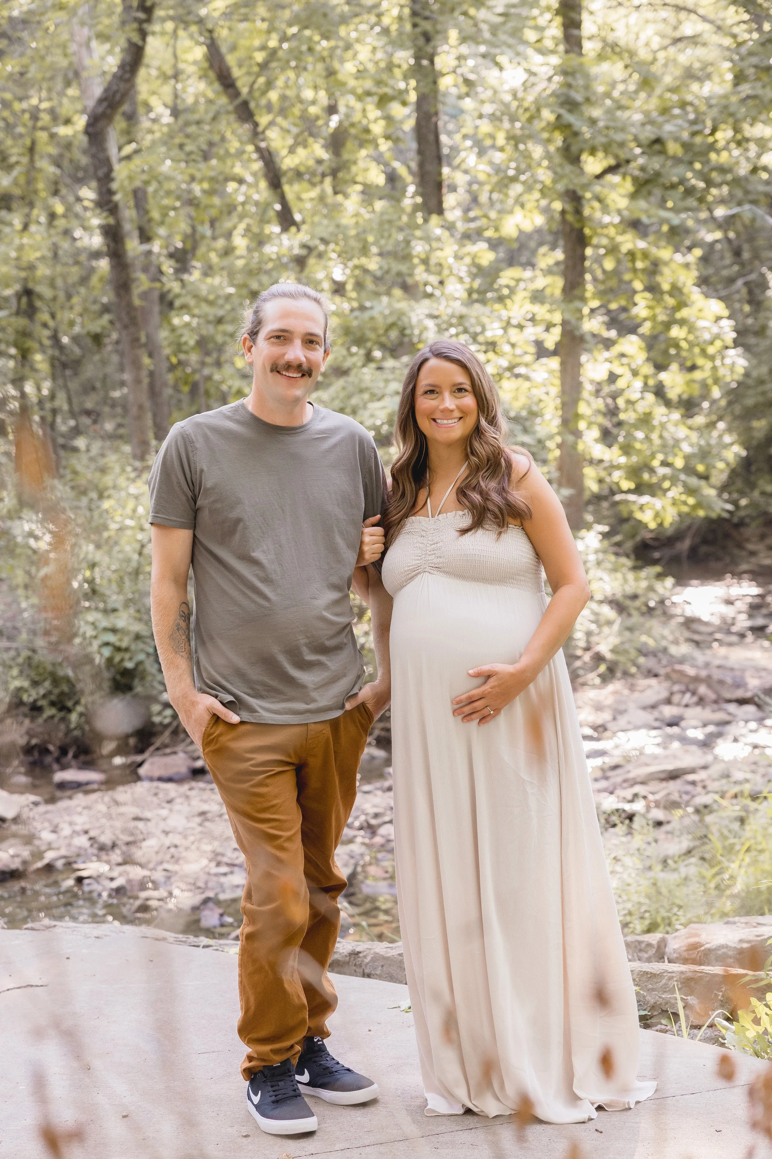 Expecting couple laughing together in Kansas City maternity session at Shawnee Mission Park