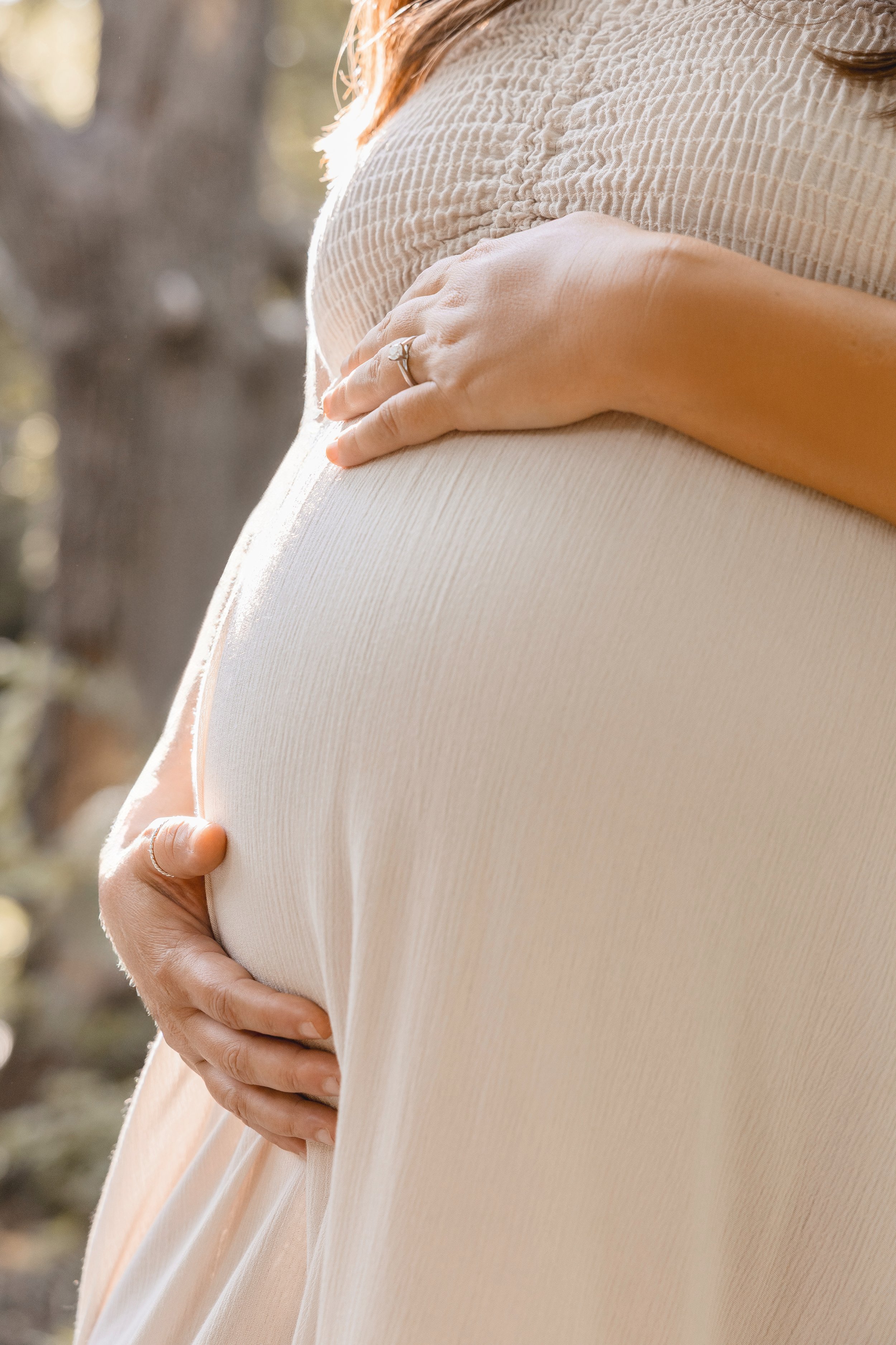Solo maternity portrait at Shawnee Mission Park, expecting mother looking down at baby bump