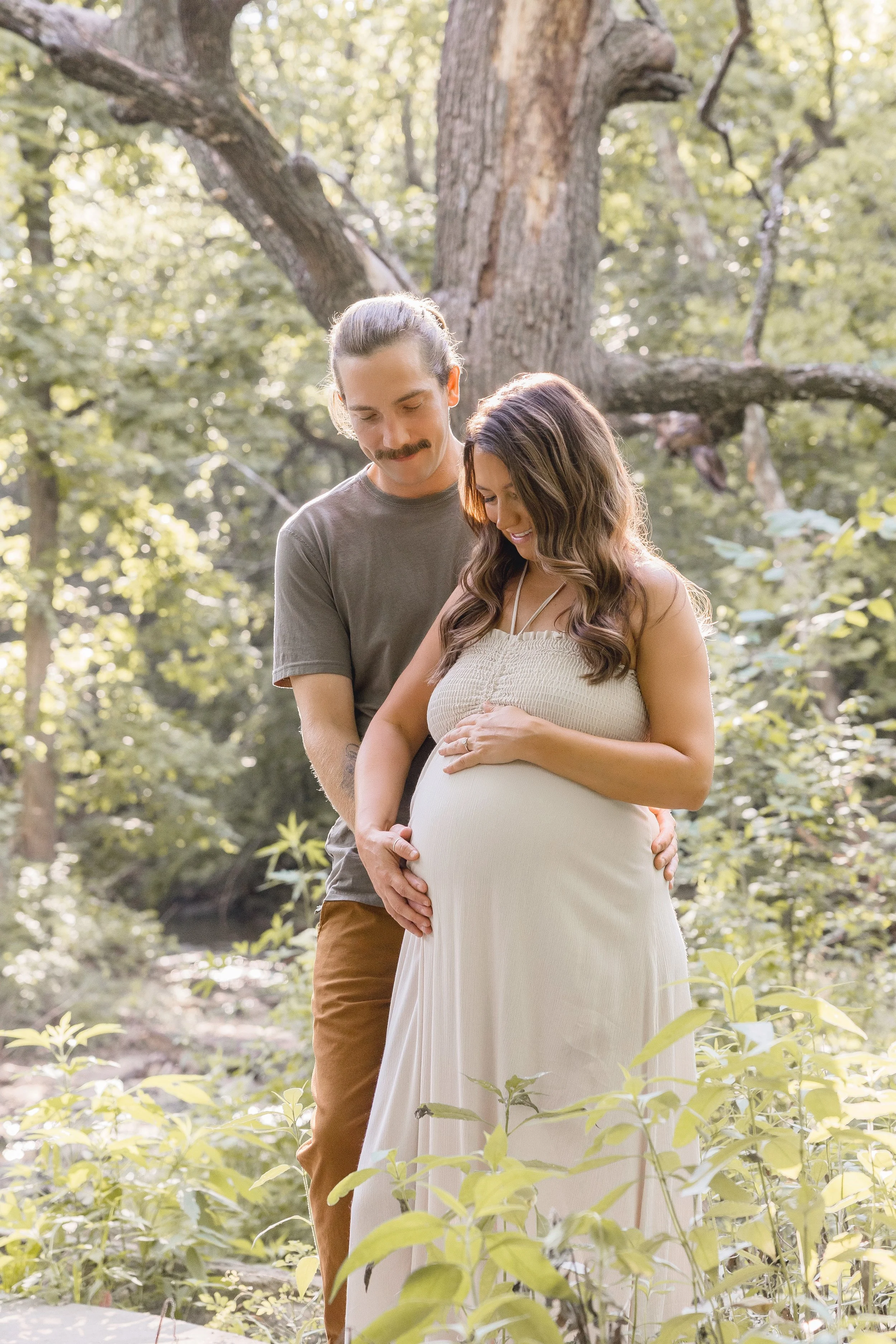 Expecting couple laughing together in Kansas City maternity session at Shawnee Mission Park