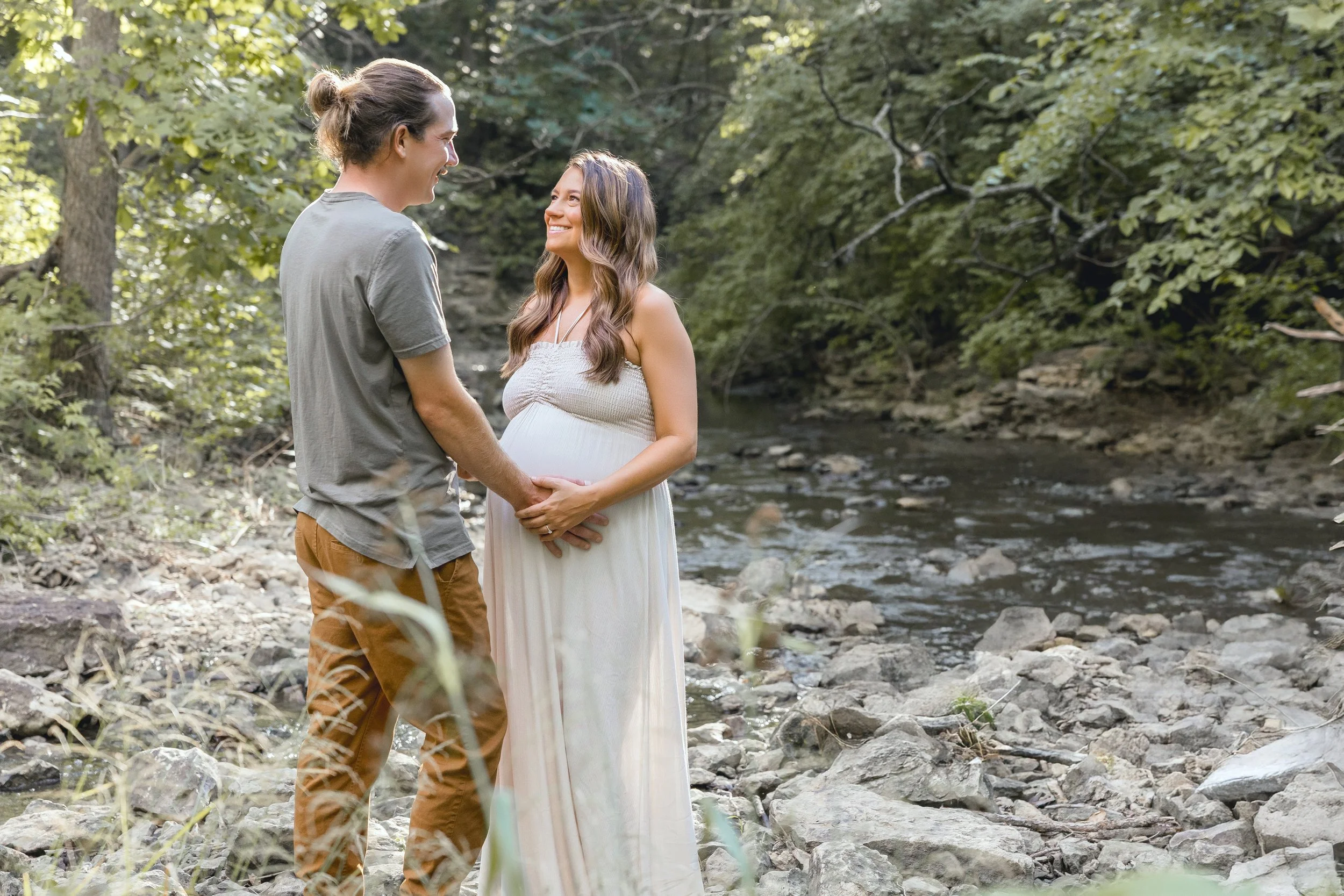Kansas City maternity portraits, expecting couple smiling during golden summer evening