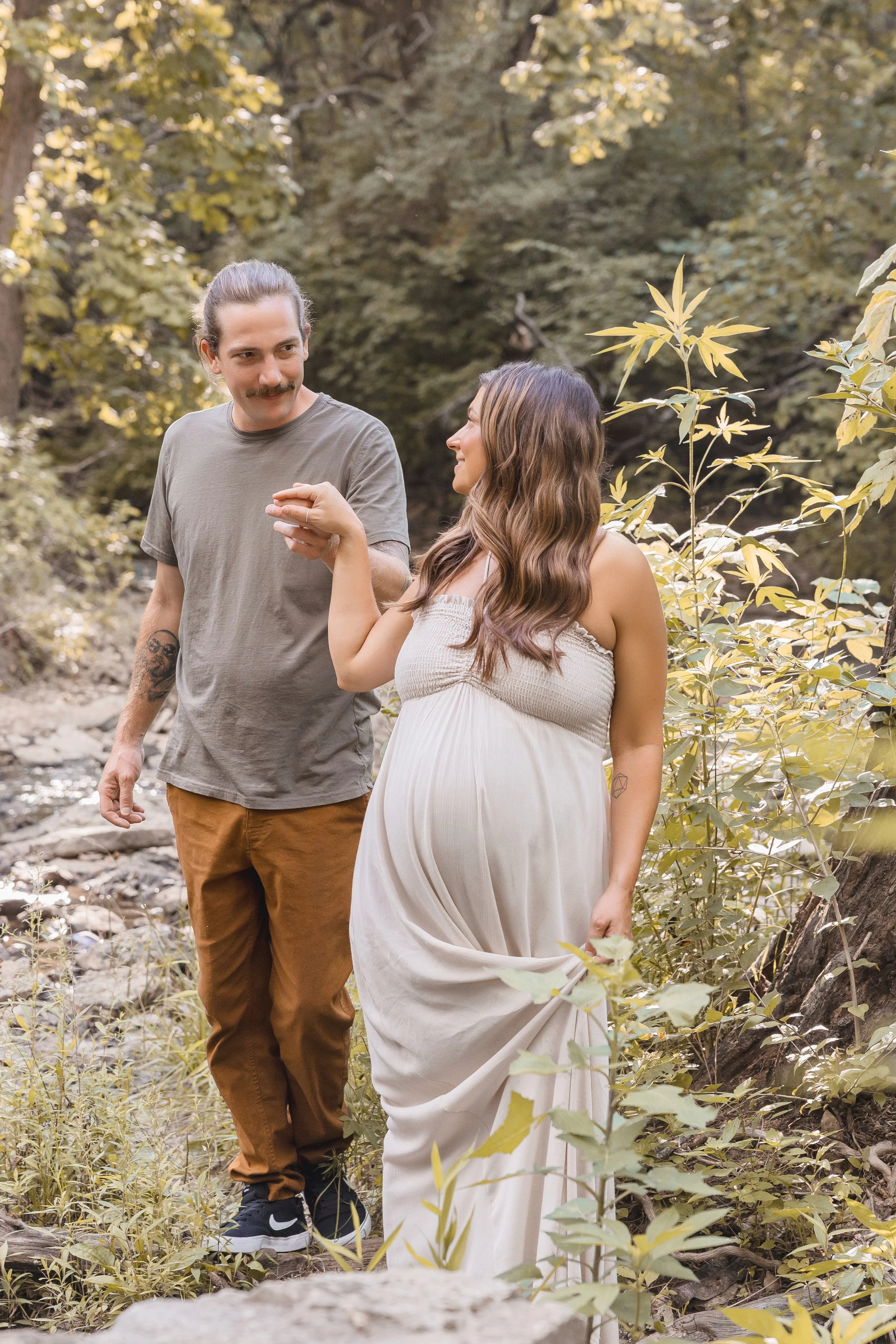 Expecting couple smiling at each other during maternity session in Kansas City, Shawnee Mission Park