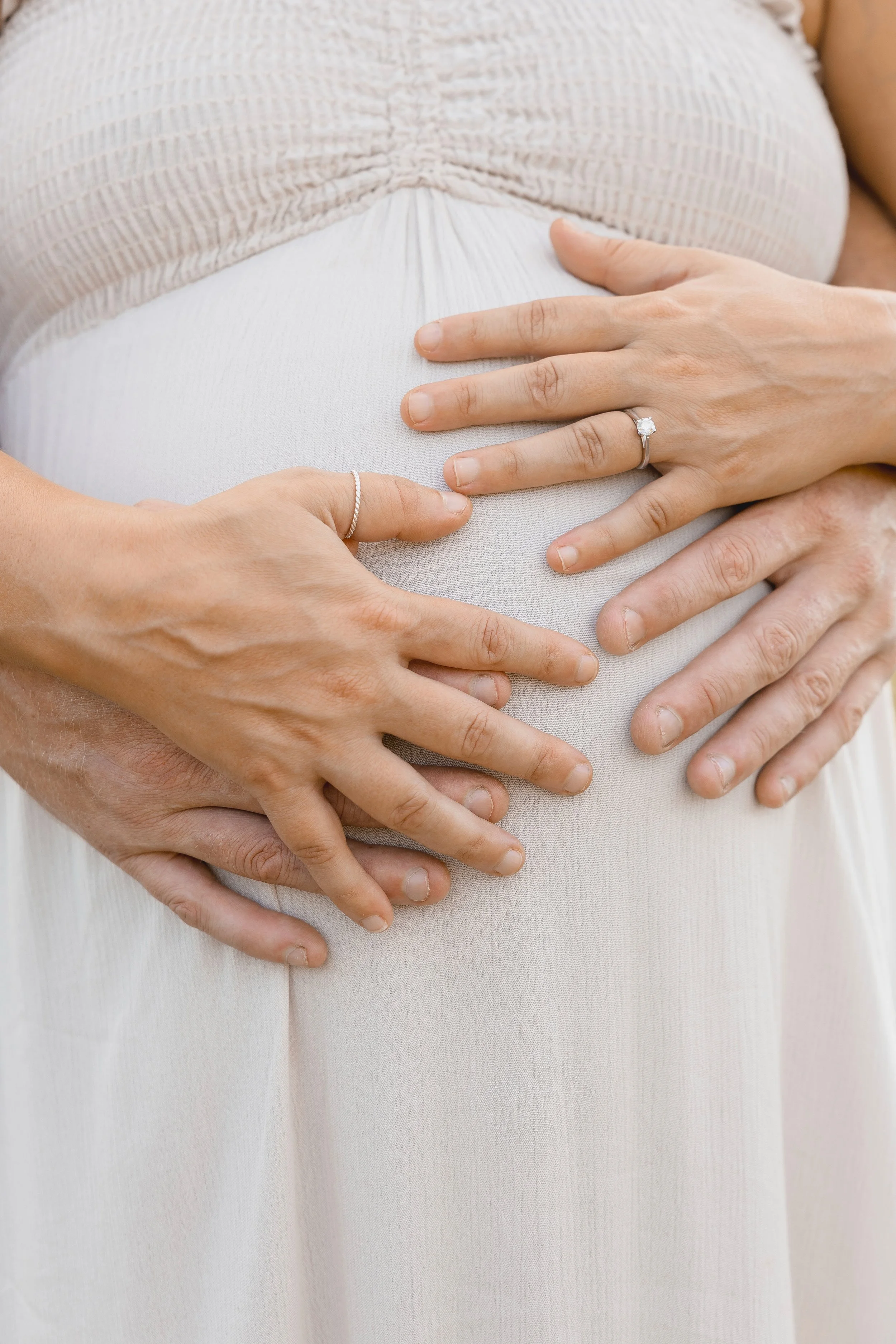 Detail of expecting parents’ hands on baby bump, Shawnee Mission Park maternity portraits in Kansas City