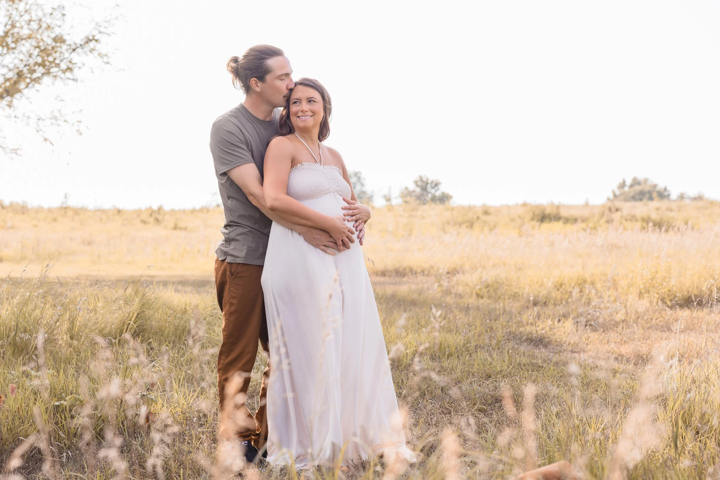 Kansas City maternity session at Shawnee Mission Park, couple holding each other in open summer field