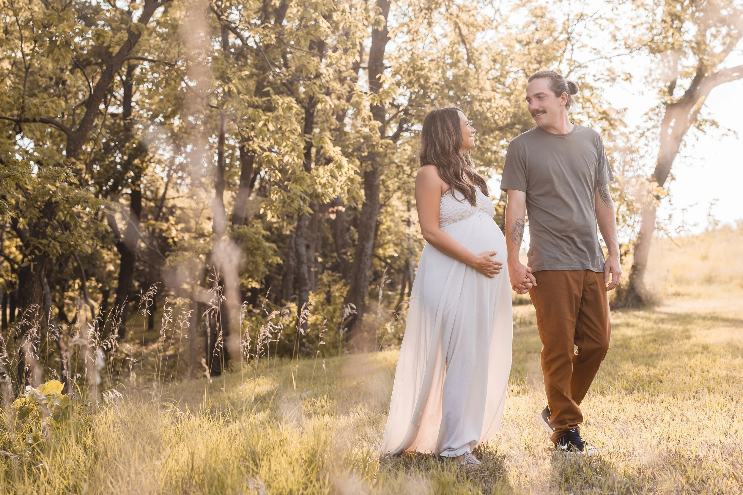 Summer maternity portraits in Kansas City, couple walking hand in hand through Shawnee Mission Park