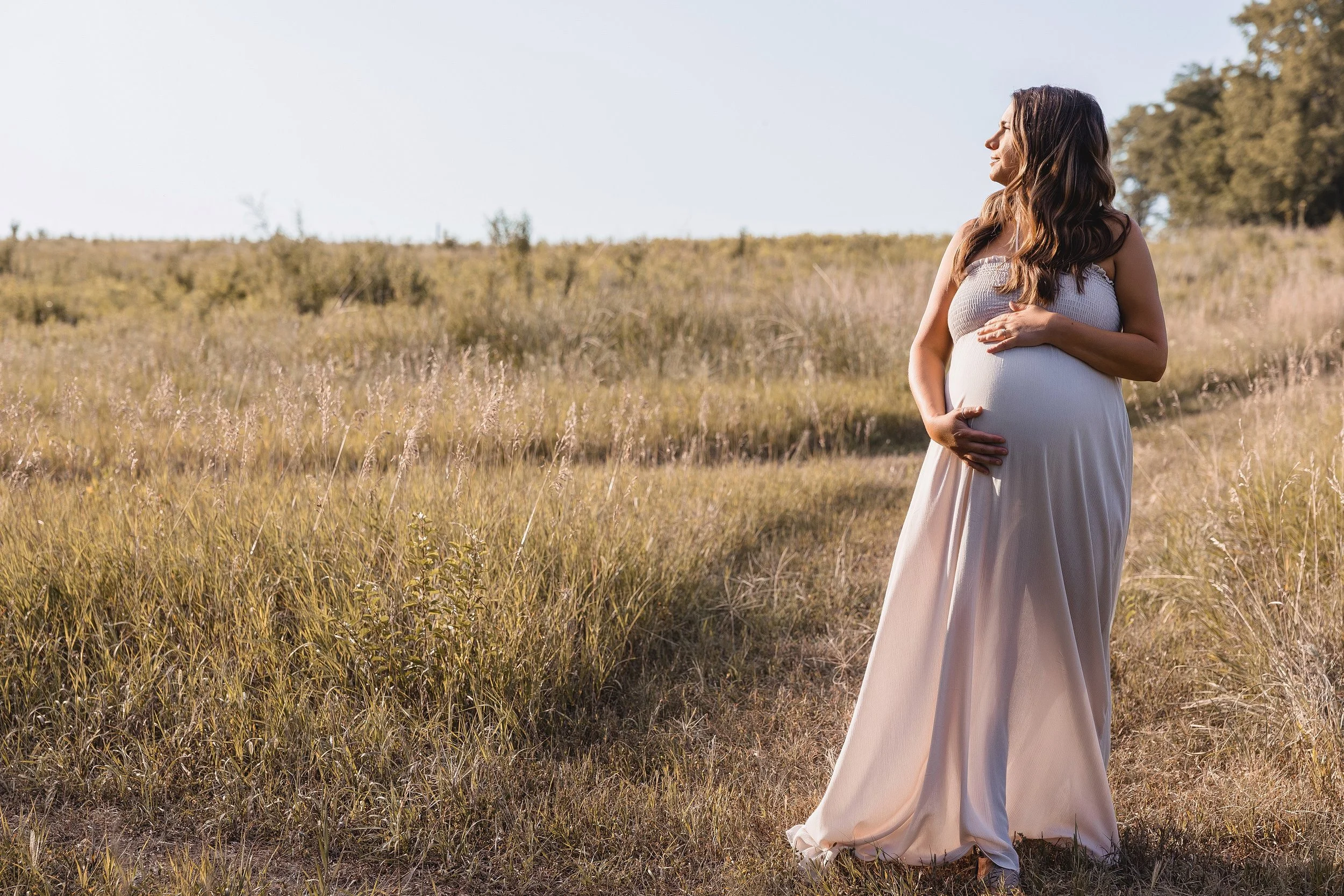 Kansas City maternity session, expecting mother in flowing gown standing in tall grass at Shawnee Mission Park
