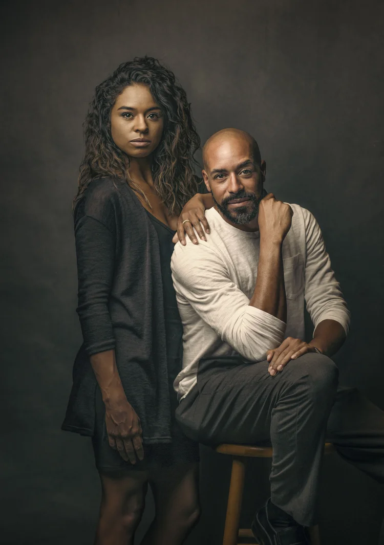 Couple portrait, woman standing beside a seated man, studio