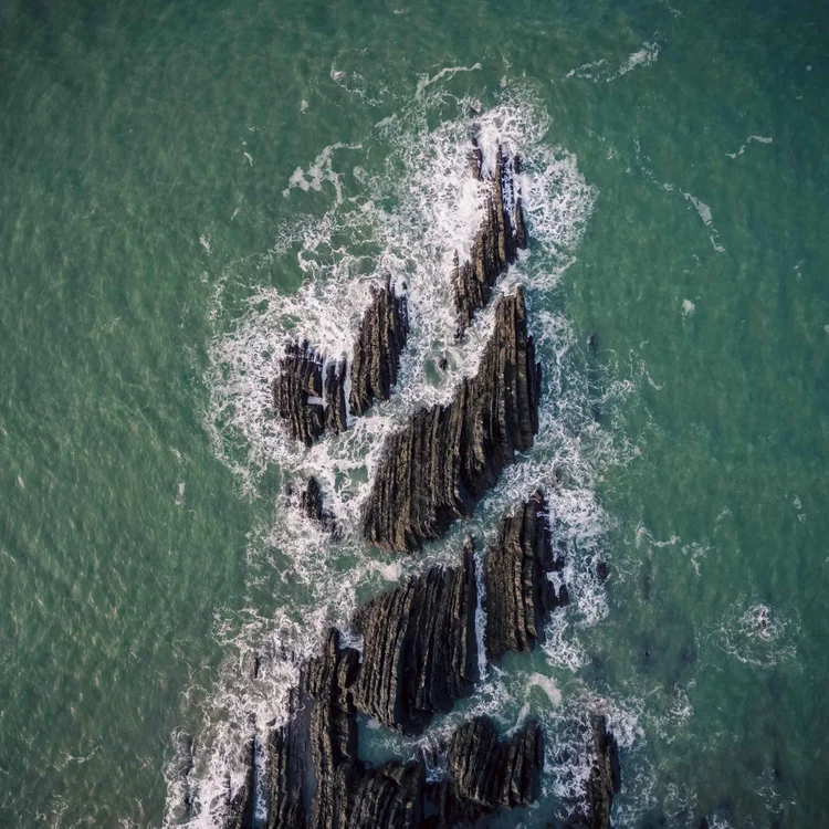 Aerial view of rocks in a turquoise sea at Hartland Quay, Devon
