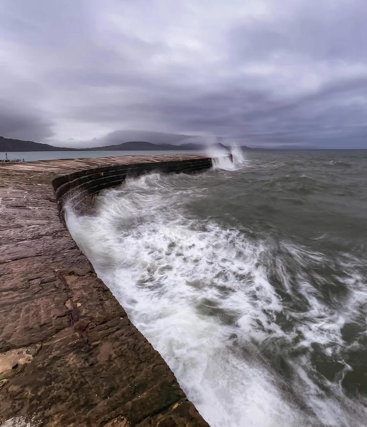 Waves breaking over The Cobb at Lyme Regis