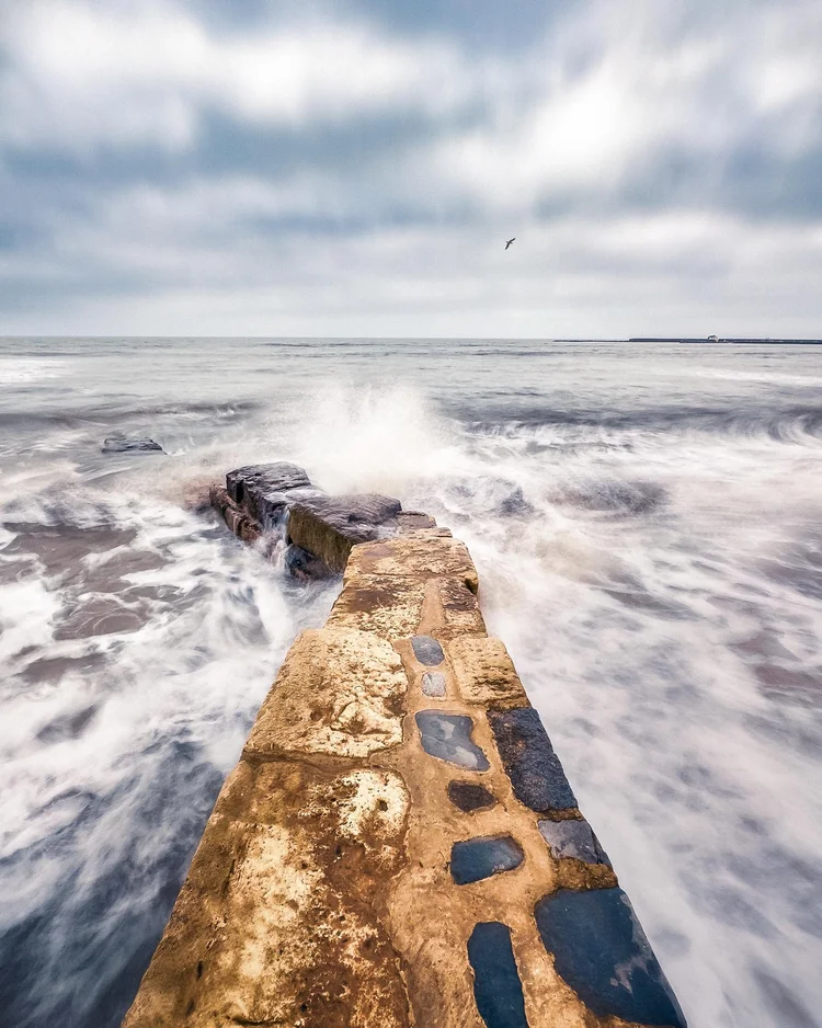 Waves washing over a groyne at Lyme Regis