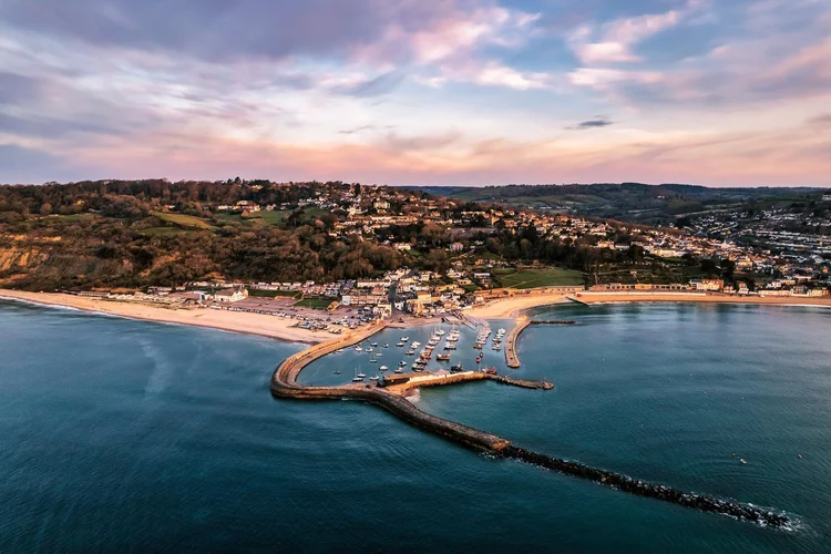 Aerial view of Lyme Regis harbour and The Cobb at sunset
