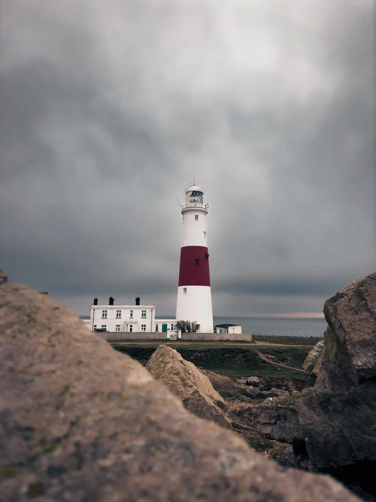Red and white lighthouse above the rocks at Portland, Dorset