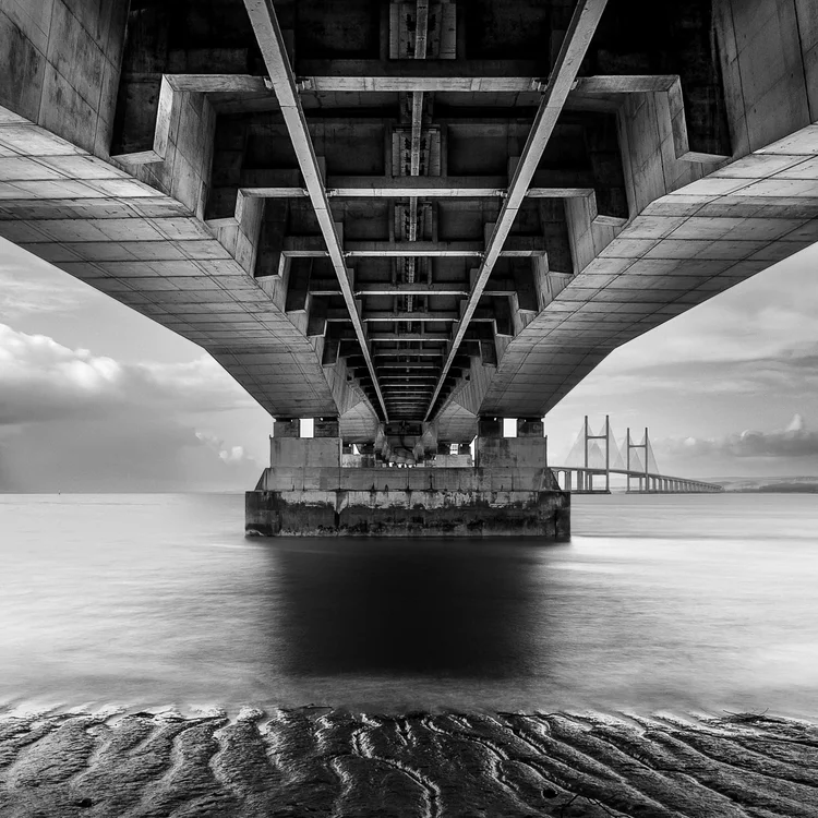 Black and white view beneath the Prince of Wales Bridge over the sand