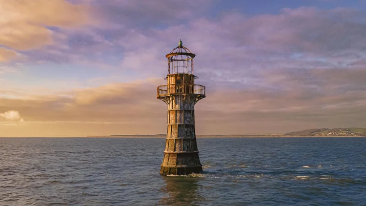 Whiteford Lighthouse standing in the sea at sunset, Wales