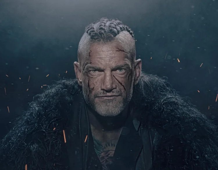 Viking warrior with braided hair and a fur cloak among glowing embers