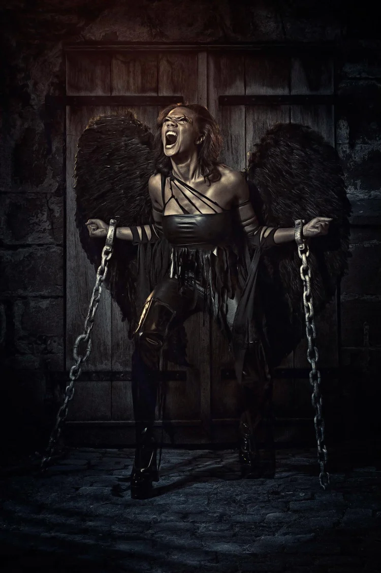 Dark fantasy composite of a woman in chains in a gothic doorway