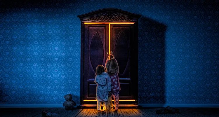 Small child standing before a glowing doorway in a blue room
