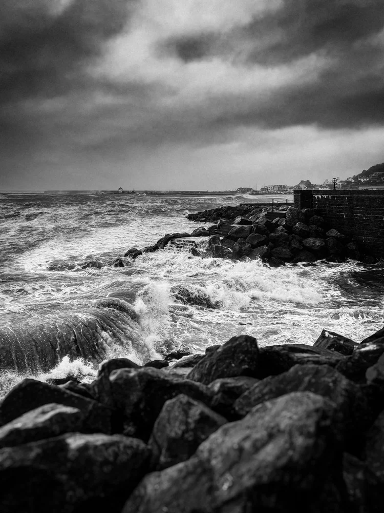 Black and white image of waves breaking on rocks at Lyme Regis