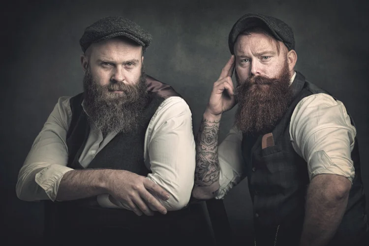 Two bearded men in flat caps and waistcoats, studio portrait