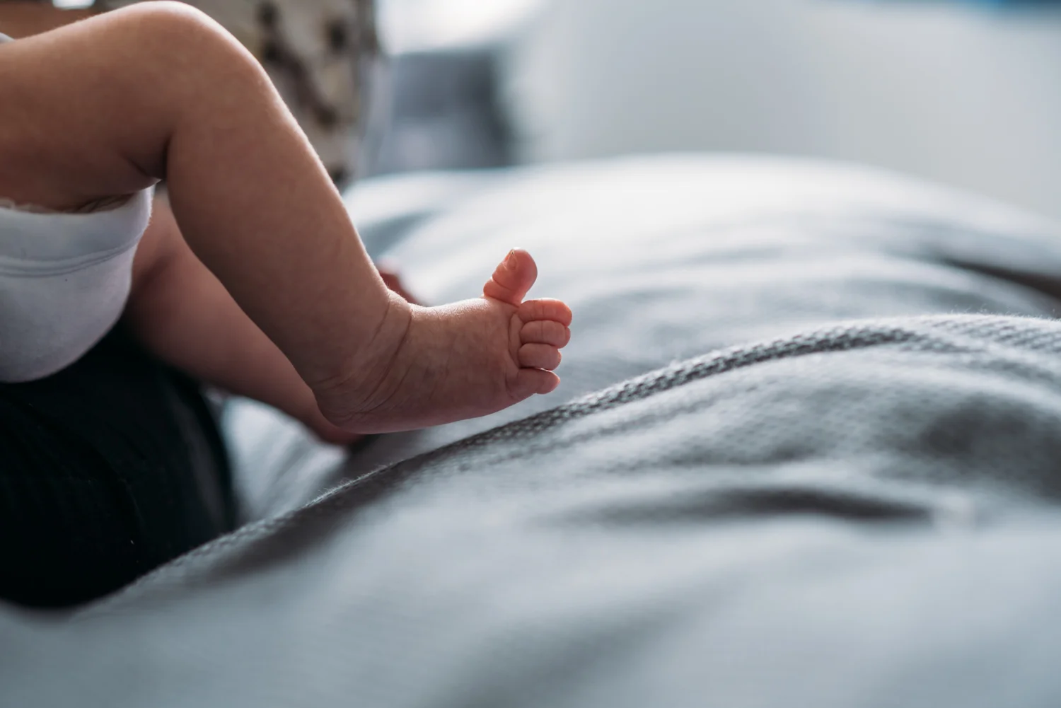 A tiny newborn baby foot stretches its toe during this newborn family photography shoot in Bristol.