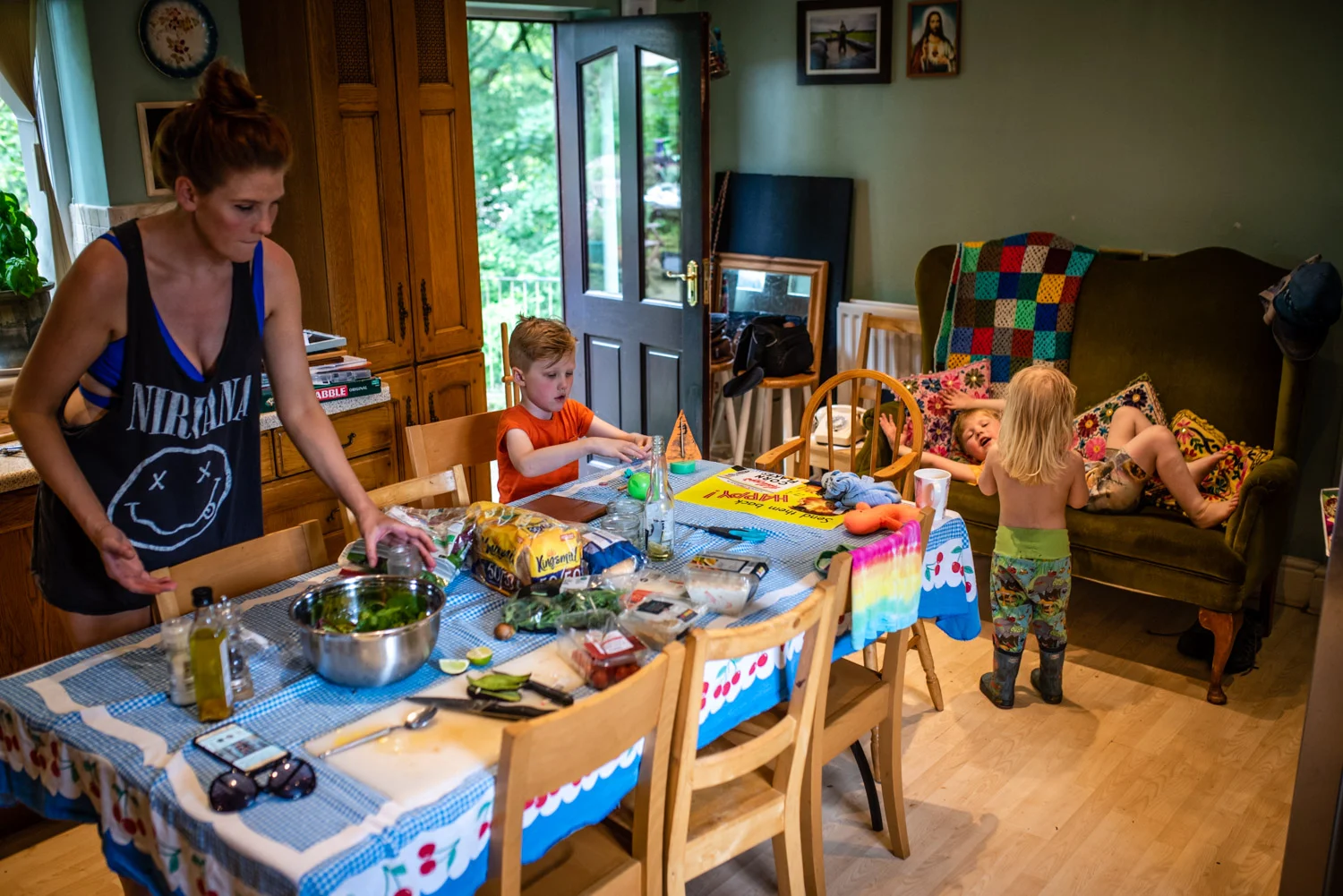 A mother and her three sons are all in their colourful kitchenn playing and preparing food during this unposed family portrait photography session.