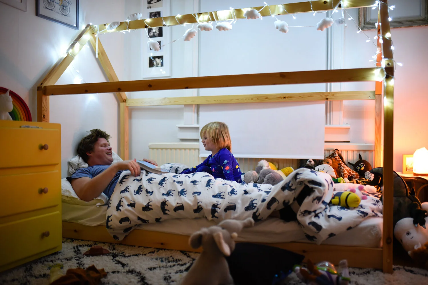 A father reads his son a bedtime story in his sons new bedroom at their home in bath somerset.