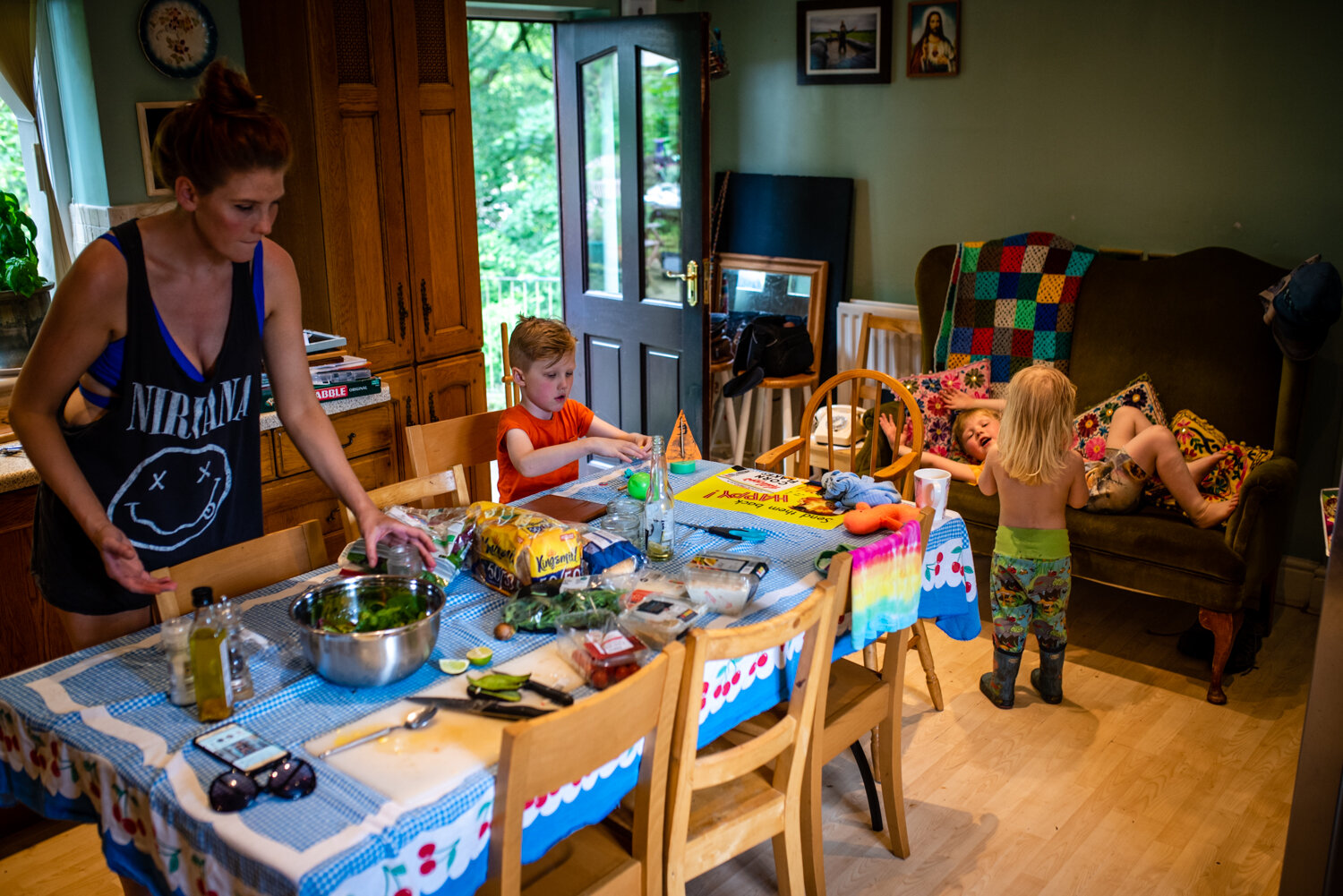  A mother and her three sons are all in their colourful kitchenn playing and preparing food during this unposed family portrait photography session. 