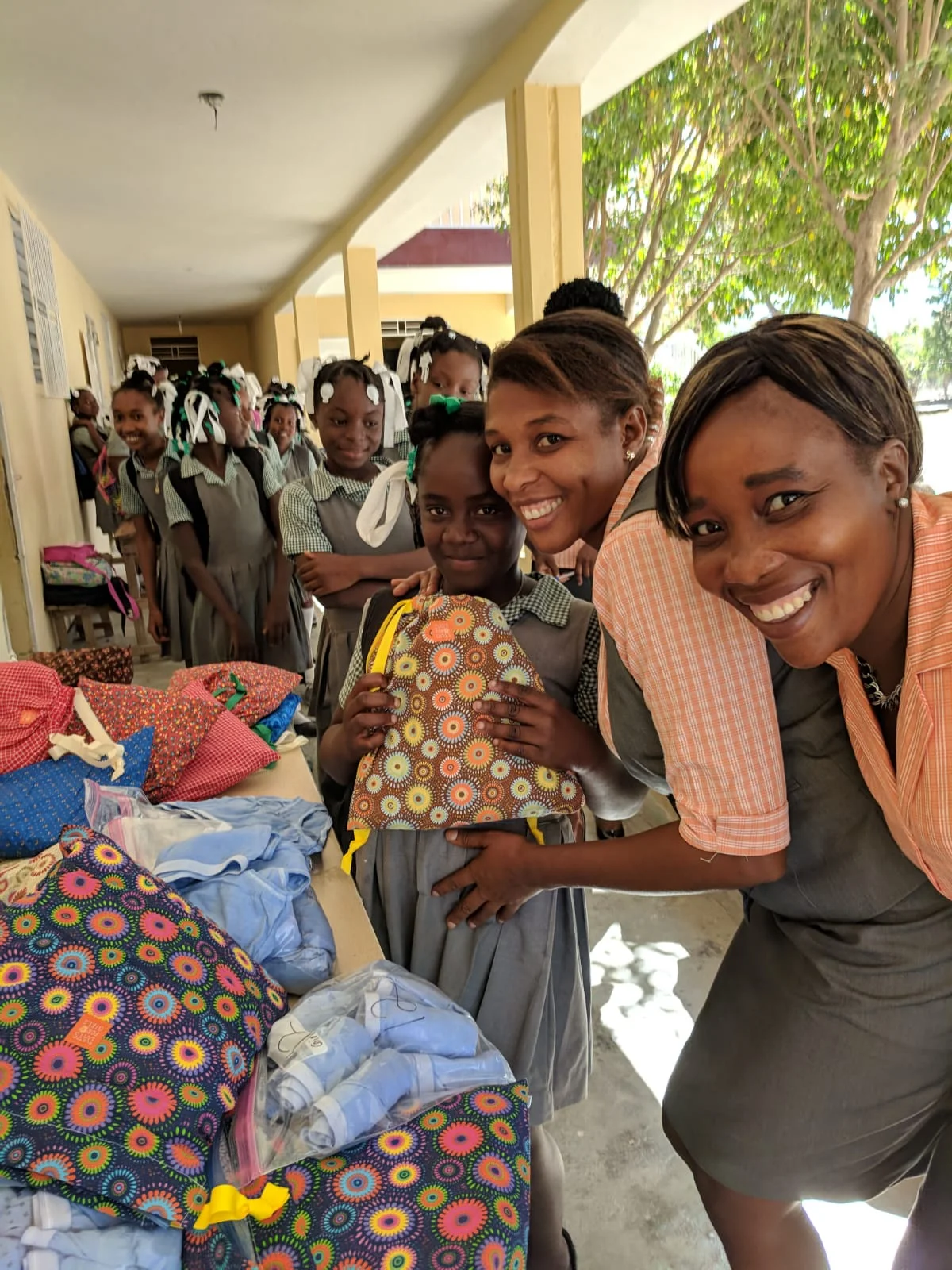 Darline (second from right) gives each GEM participant a menstrual health kit at a recent meeting)