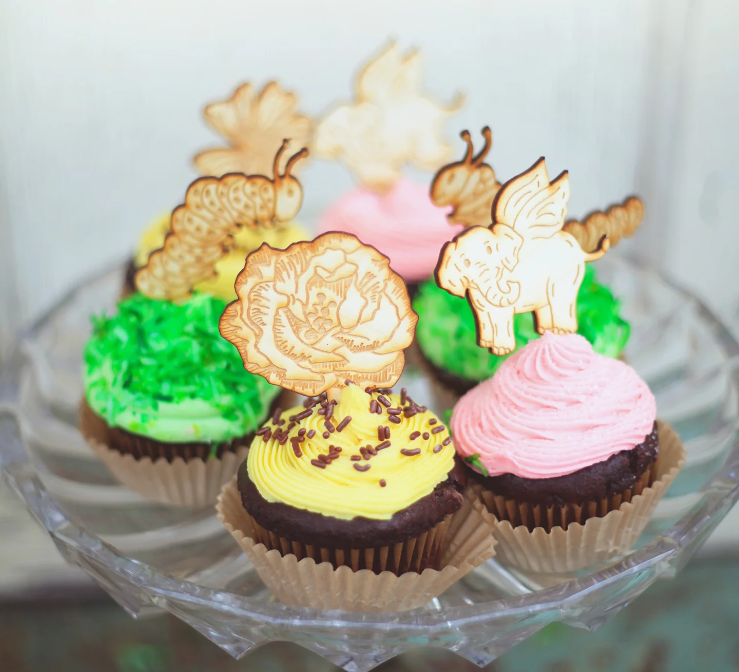 Whimsical illustrated cupcake toppers, engraved onto baltic birch wood for a special event.