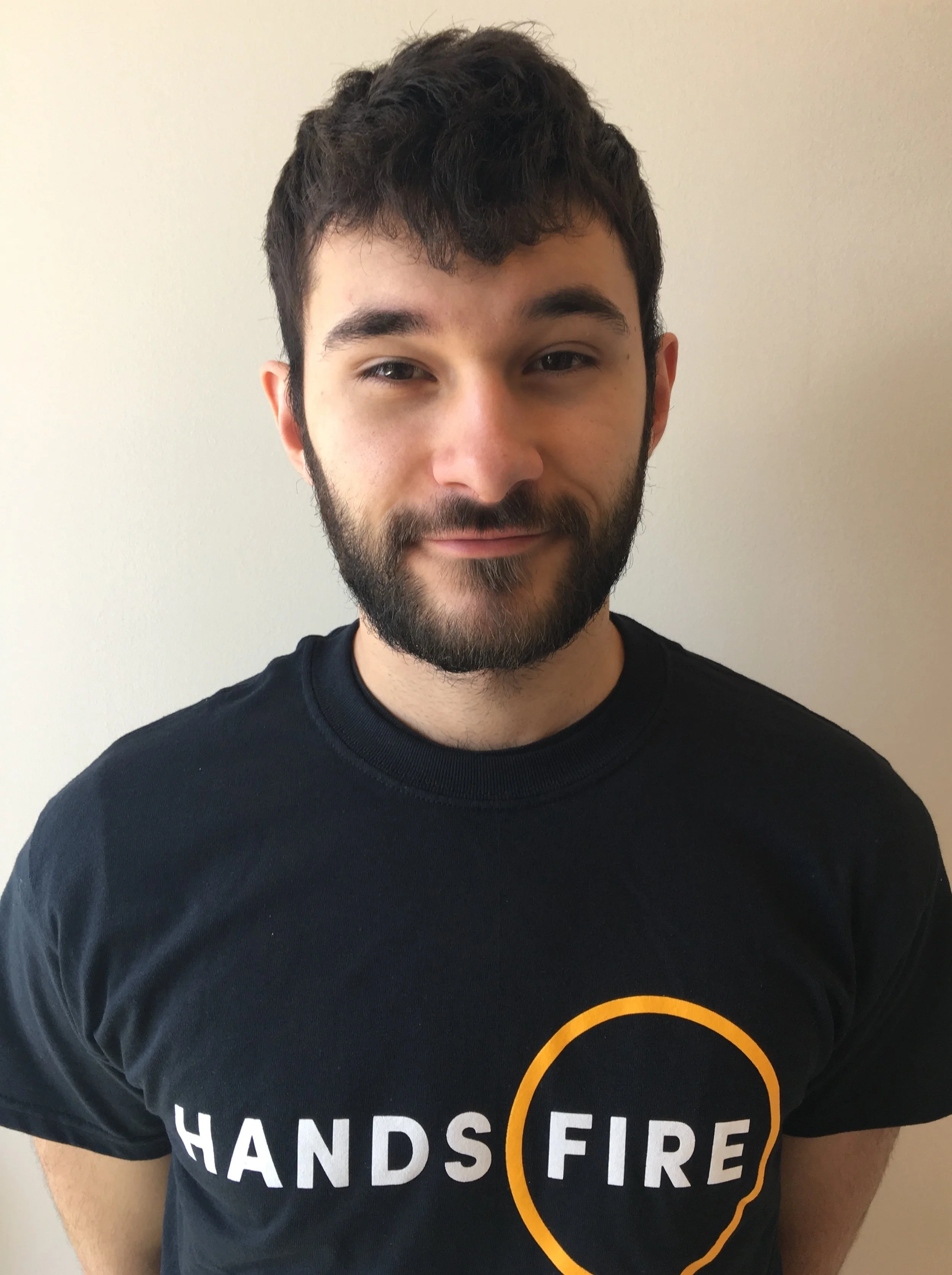Photo Description: Douglas Free smiling wearing a black t-shirt with the Hands of Fire logo on in the centre.