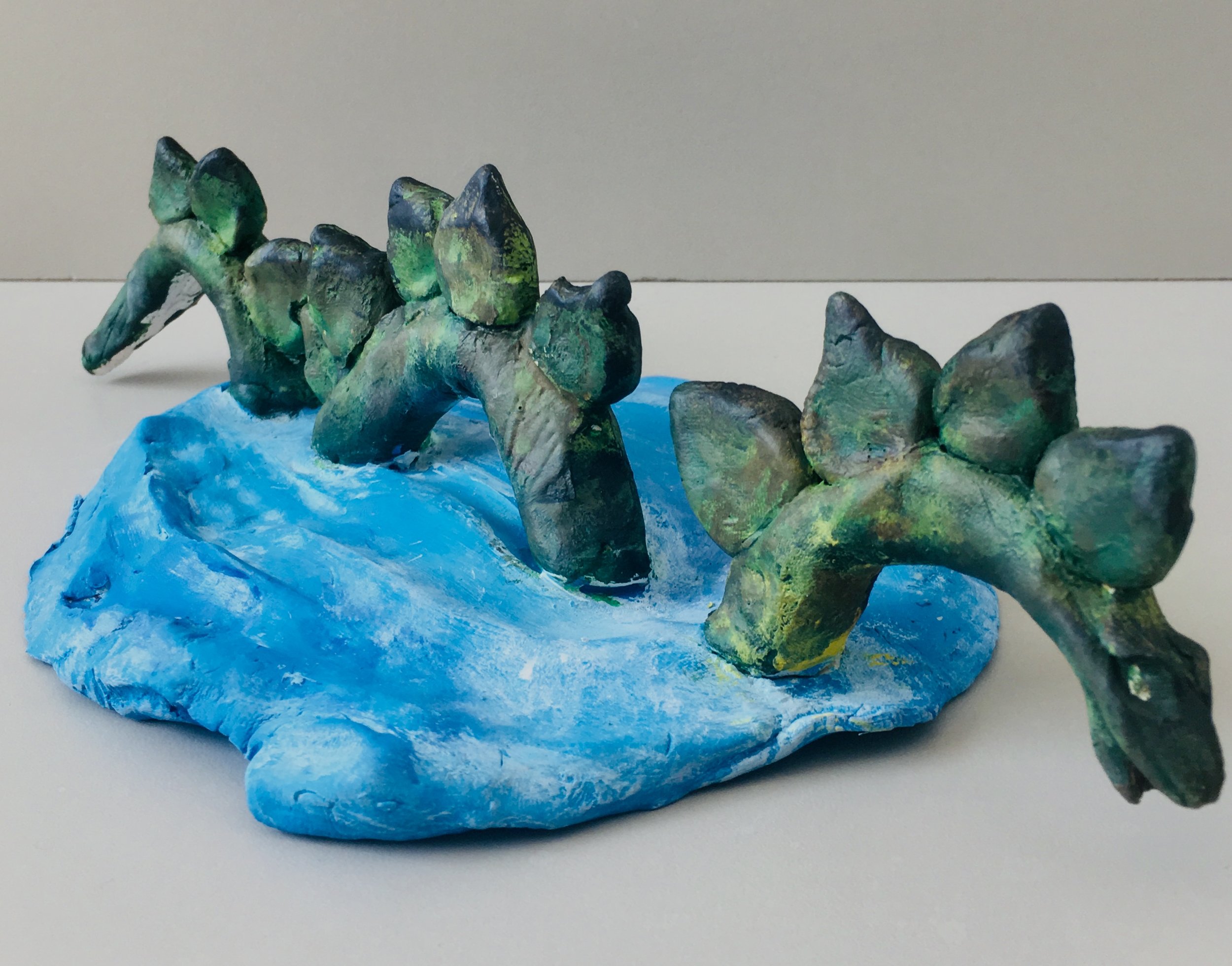 Photo Description: Green Lochness monster in blue water.