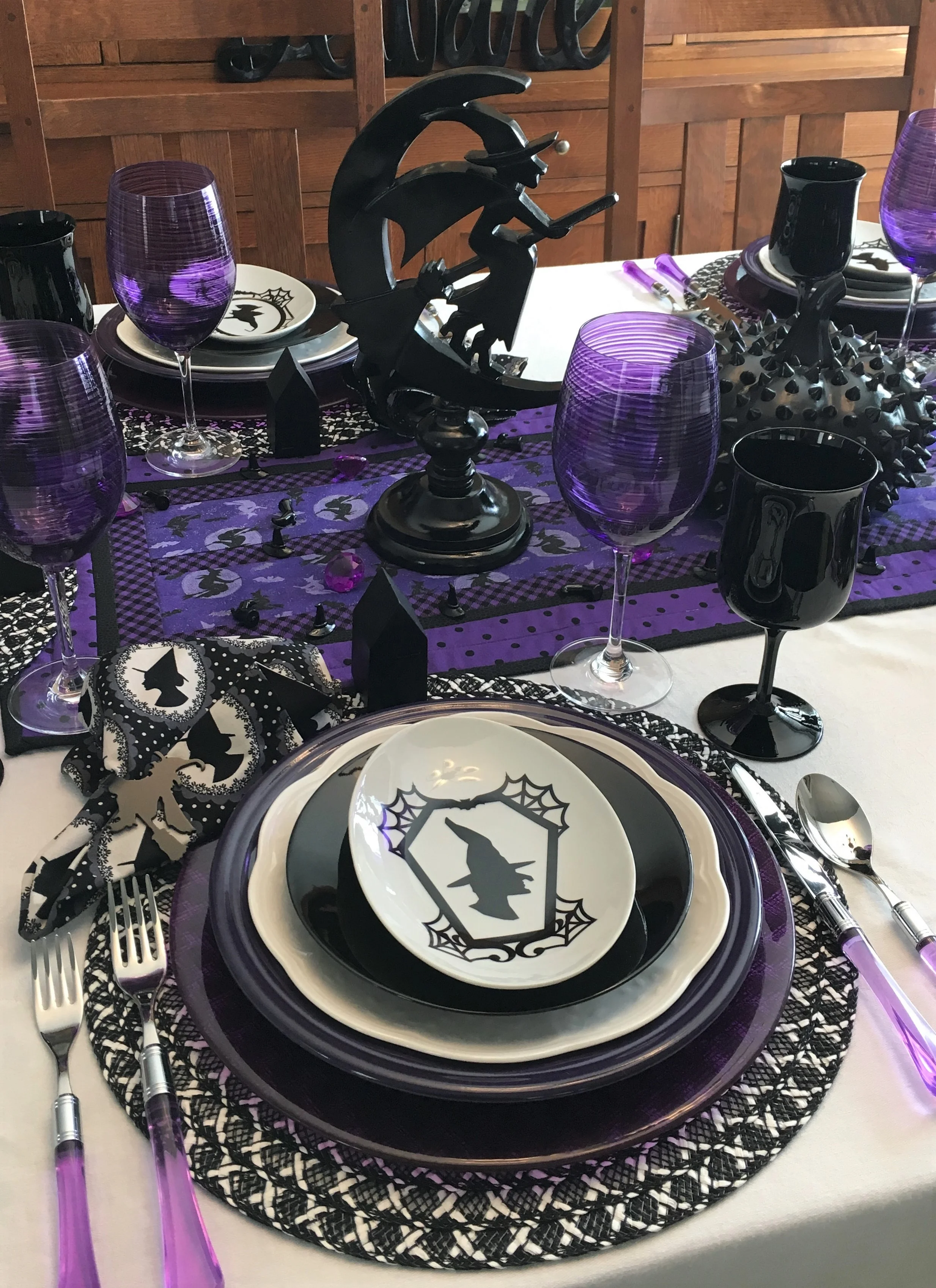 The witch centerpieces came from Pier1. They were a distressed black and I am not a fan of distressed wood so my hubby spray painted them for me, love the way they turned out. The black studded pumpkin is from Pier1 as well as the place mats. Pier1 has good sales from time to time. The chargers are Bormioli Rocco Inca in purple and I bought them on sale on Amazon. Have a few other colors of this one, it is really heavy glass. The picture looks dark but it is a really pretty purple color. Found the purple goblets at HomeGoods. I was able to get 6 at one store and 6 at another one. The black goblets came from Ebay, they are Premiere by the Libbey Glass Company.