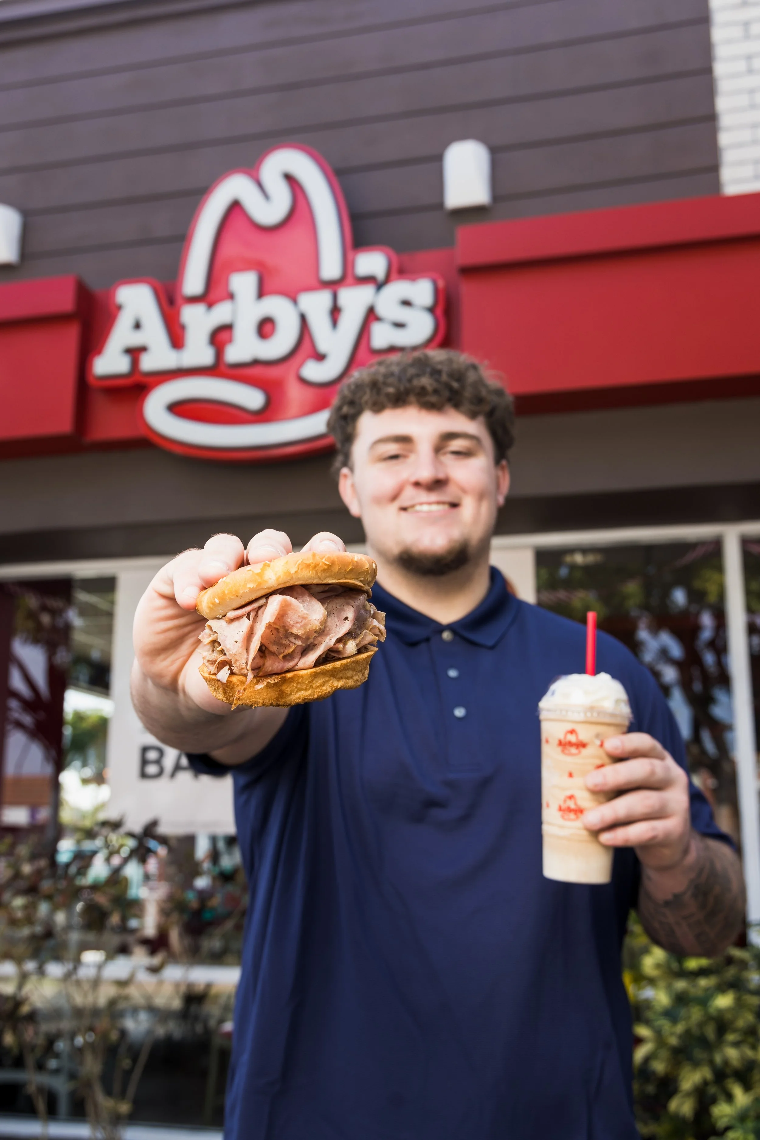 Mason Graham poses with the Arby's sandwich outside a local Arby's