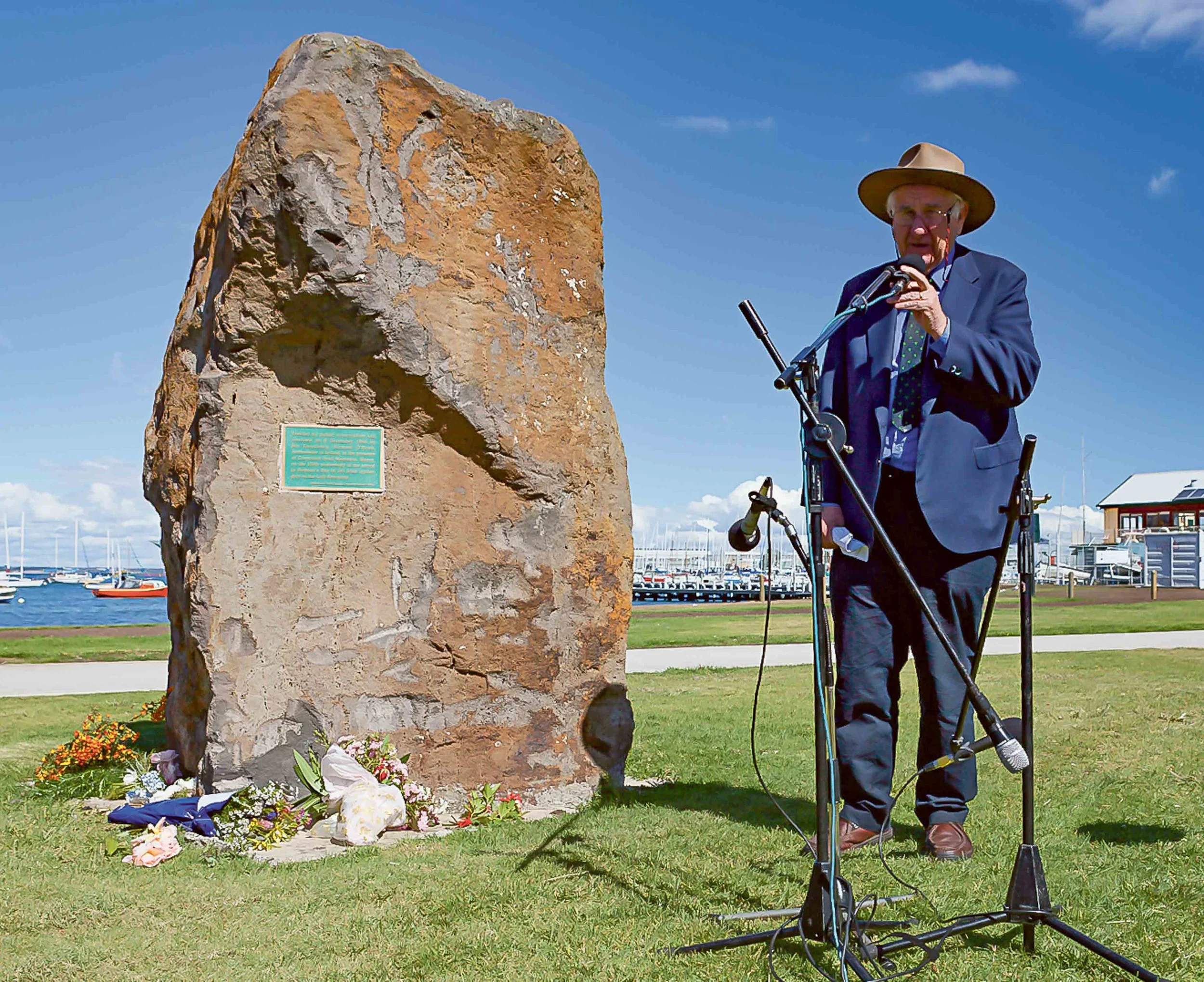 Dr Val Noone next to the Famine Rock at Williamstown.
