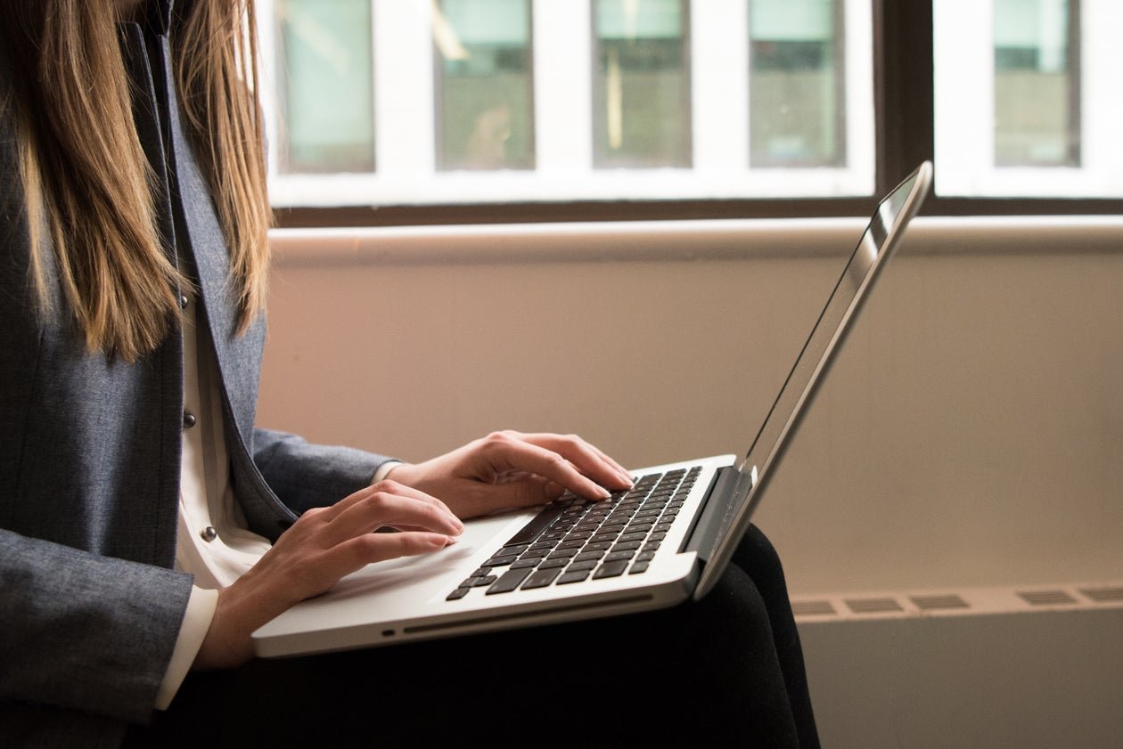 Person working on a laptop in a bright office setting.