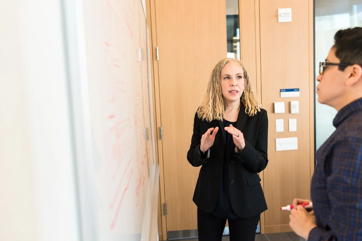 Two professionals discussing ideas at a whiteboard.