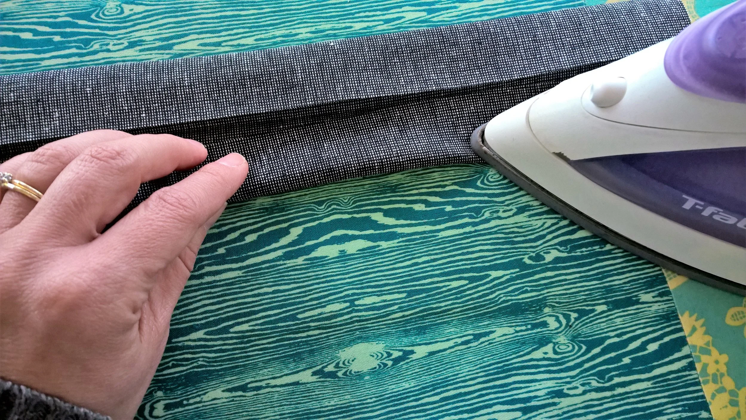Pressing bottom half towards center crease.